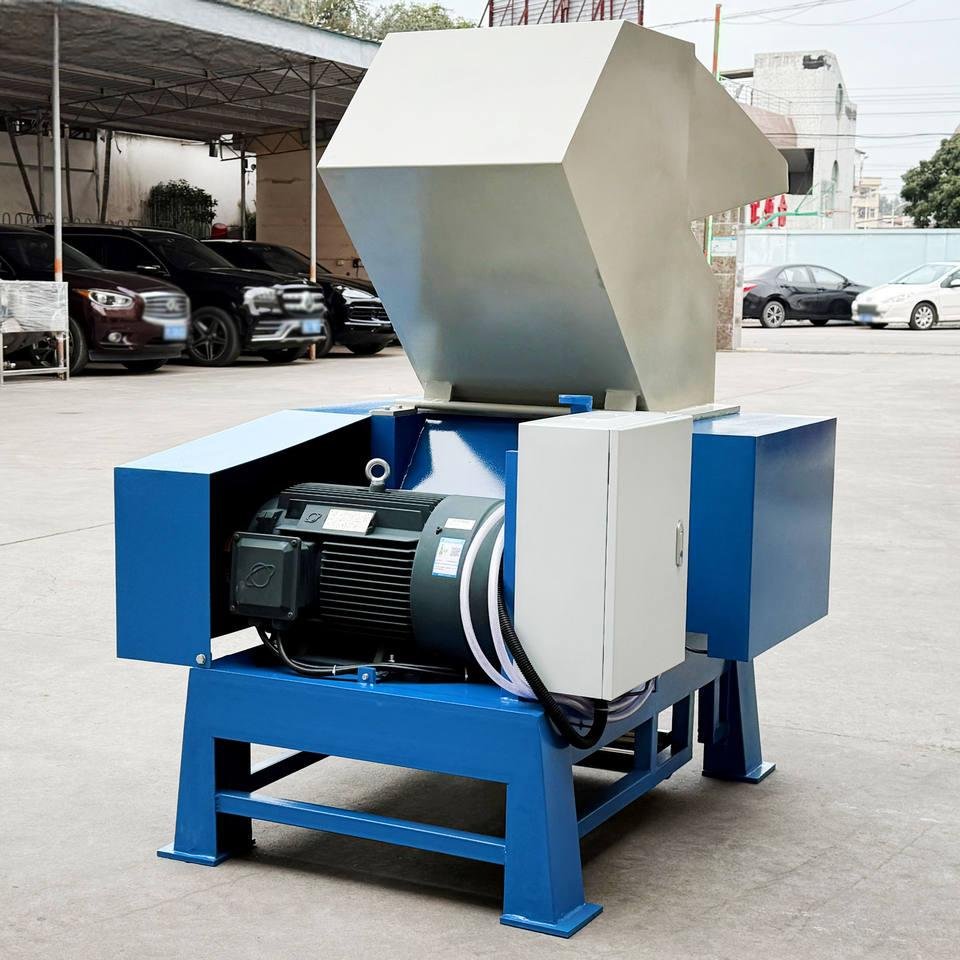 Industrial plastic shredder machine processing e-waste materials in recycling facility
